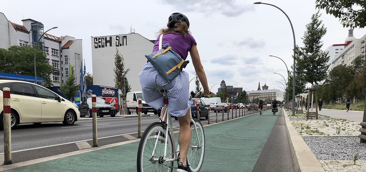 Frau auf geschütztem Radfahrstreifen Frau auf geschütztem Radfahrstreifen
